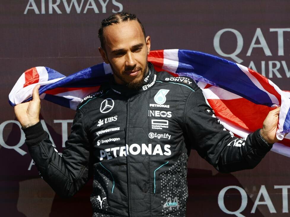 Lewis Hamilton mit der britischen Flagge auf dem Formel-1-Podium in Silverstone 2024