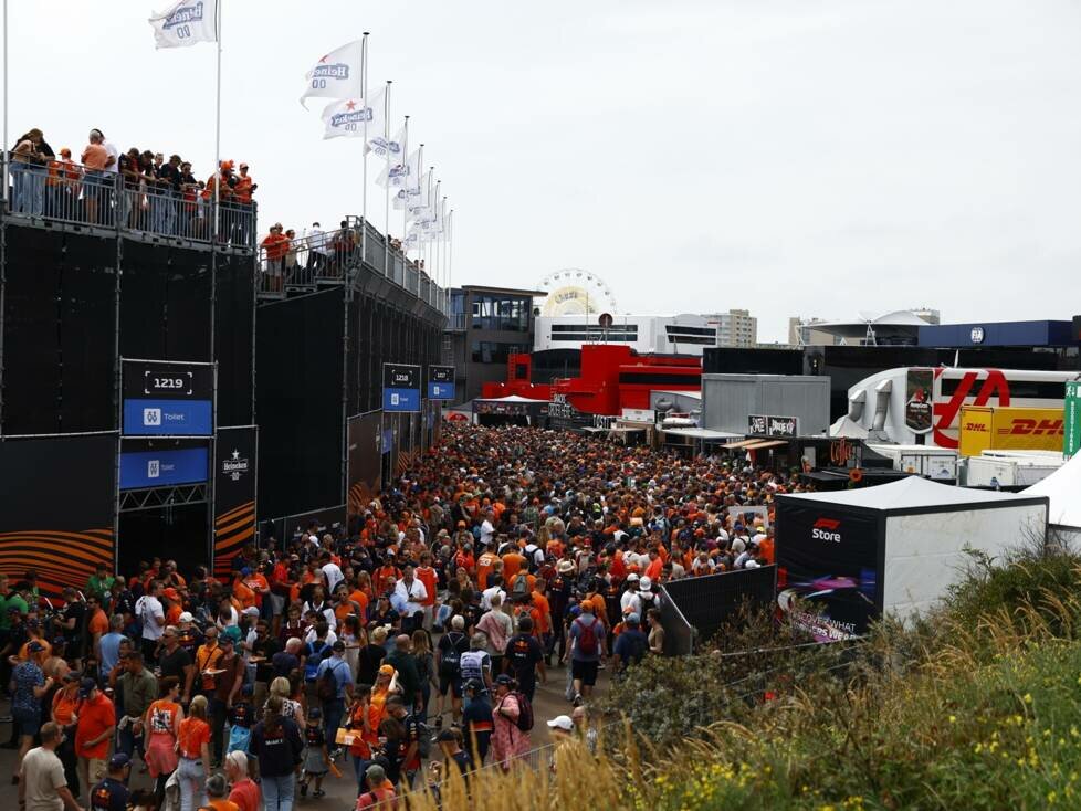 Fans strömen durch die Fan-Area zwischen Tribünen und Merchandise-Ständen