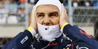 Sergio Perez zieht sich die Sturmhauber über in der Formel-1-Startaufstellung 2024
