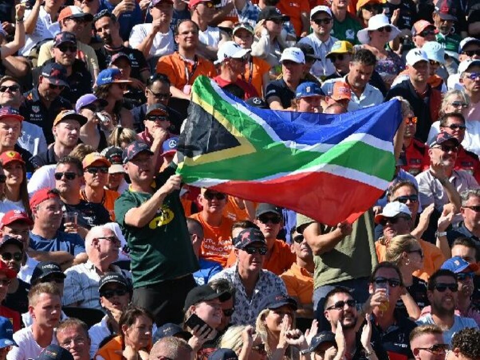 Ein Zuschauer hält die Nationalflagge von Südafrika hoch