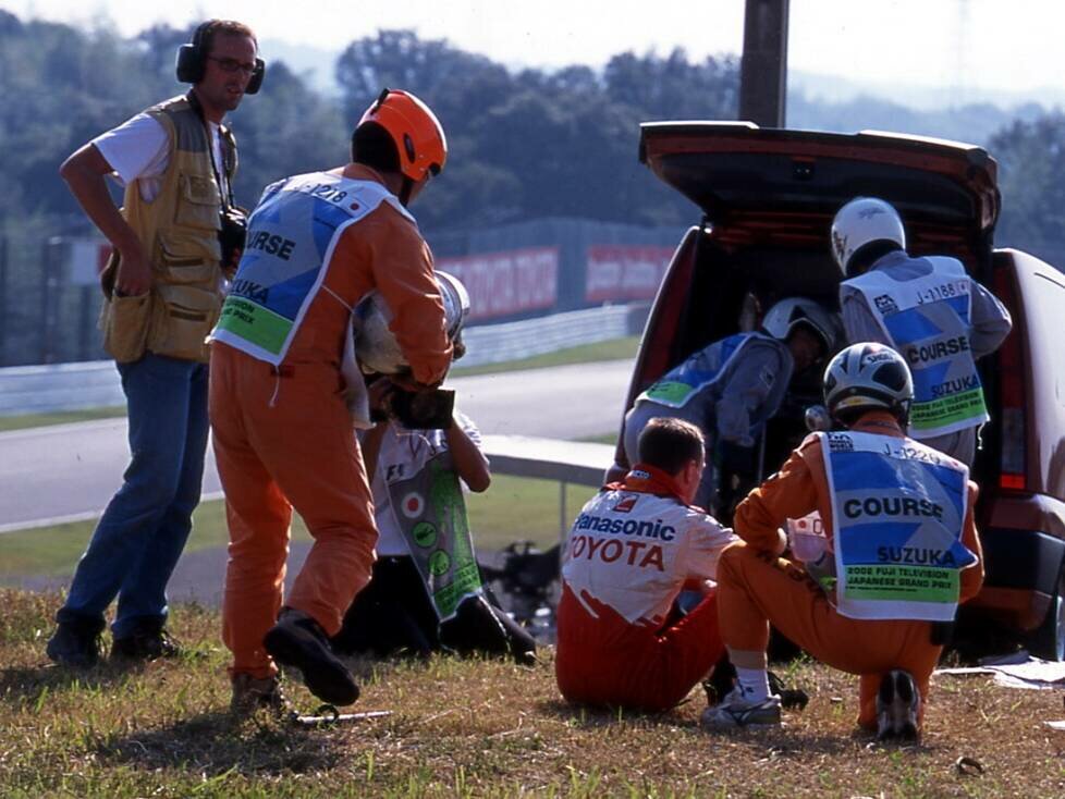 Allan McNish sitzt im Gras und erholt sich von seinem schweren Unfall 2002 in Suzuka