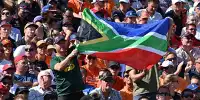 Ein Zuschauer hält die Nationalflagge von Südafrika hoch