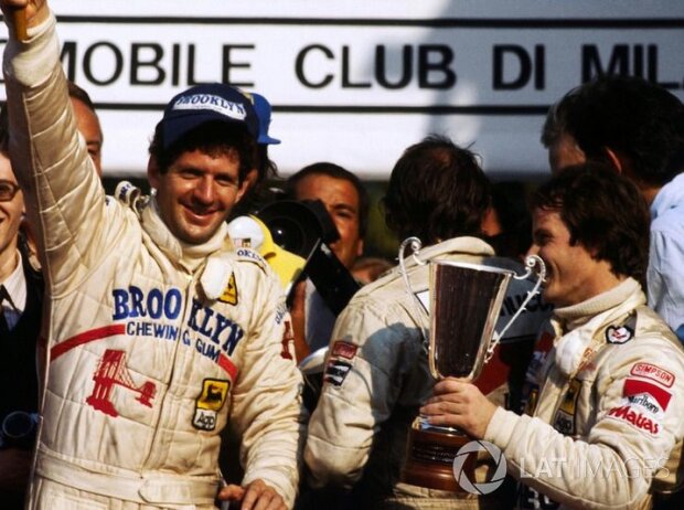 Rennsieger und Weltmeister Jody Scheckter feiert auf dem Podium mit Gilles Villeneuve, Ferrari